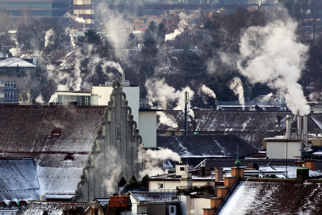 De la fumée qui sort des cheminées de plusieurs maisons