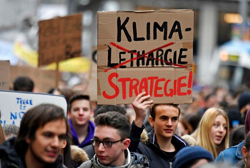 Junge Demonstrierende halten ein Schild