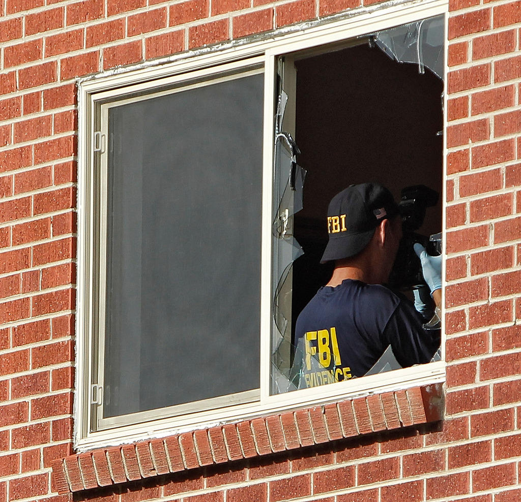 Agenti dell fbi di spalle oltre una finestra rotta