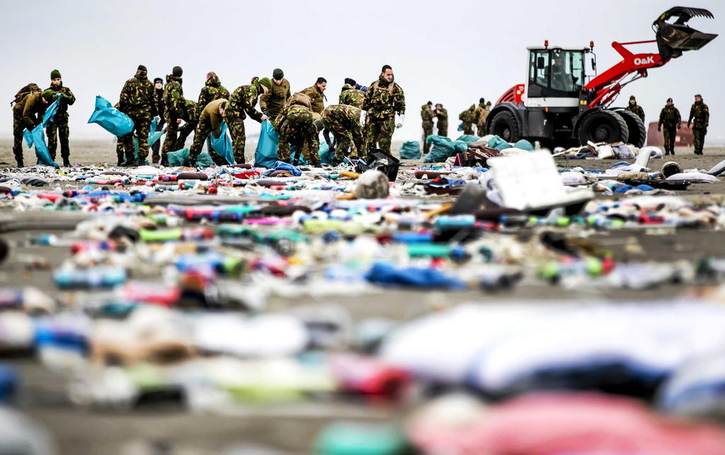 Soldiers clear up debris from a beach