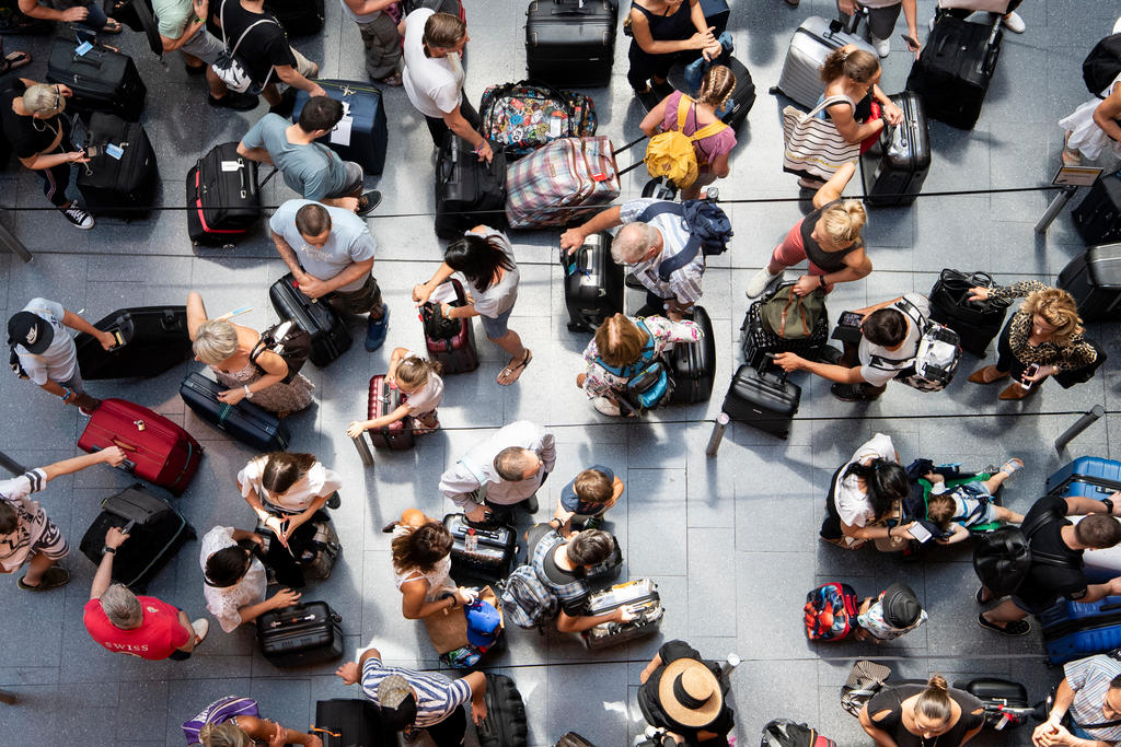 Check-in-Halle am Flughafen Zürich mit vielen Menschen von oben gesehen