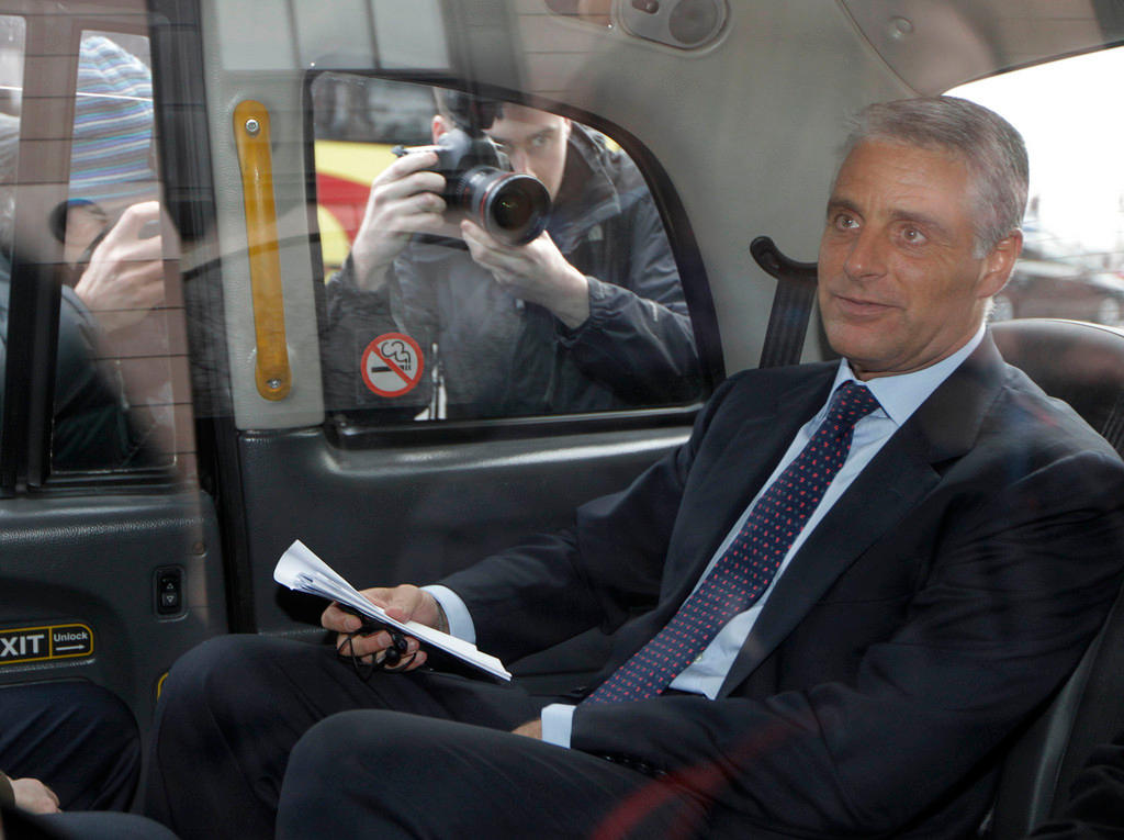Andreas Orcel in a car surrounded by photographers