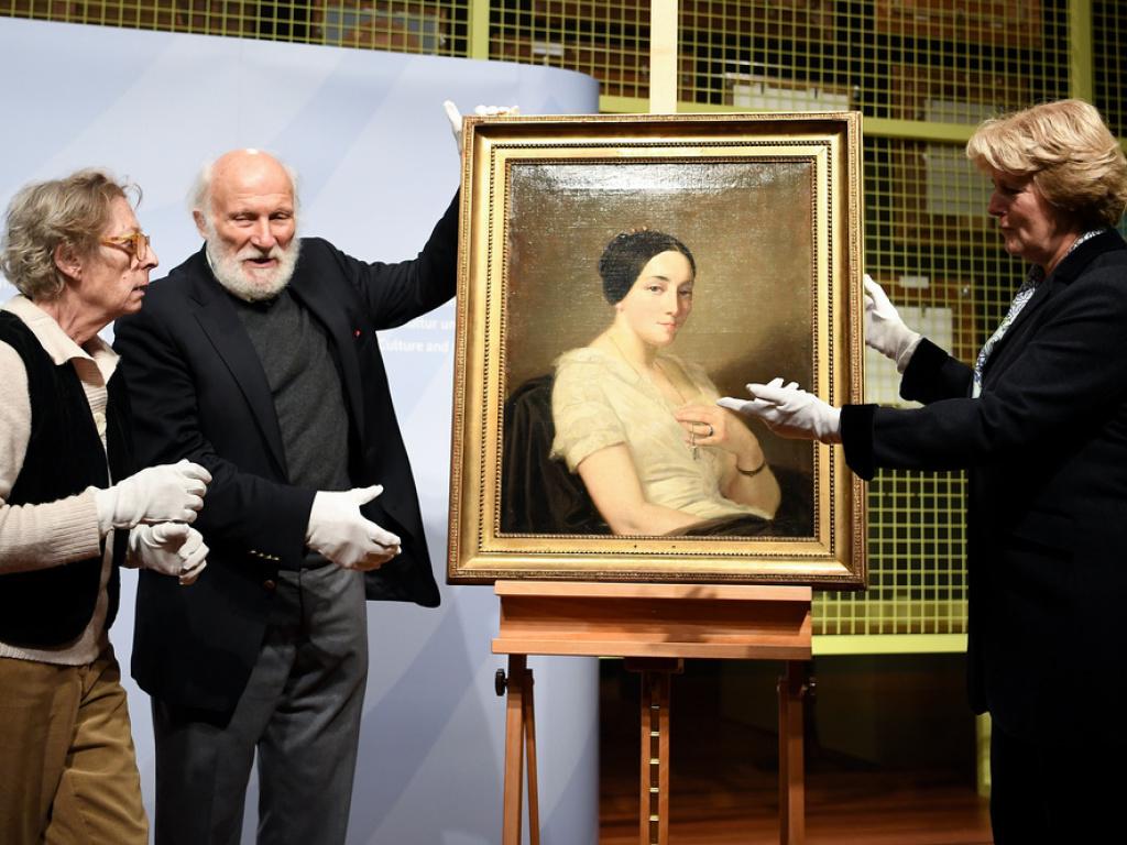The German Minister of State for Culture Monika Grütters (r) returns the painting "Portrait de jeune femme assise" (1845) by Thomas Couture found in the Gurlitt estate to the descendants of the rightful owner, January 2019.