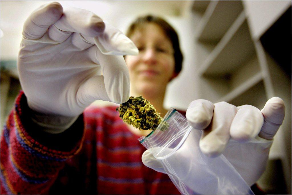 Mulher colocando flor de maconha em um recipiente