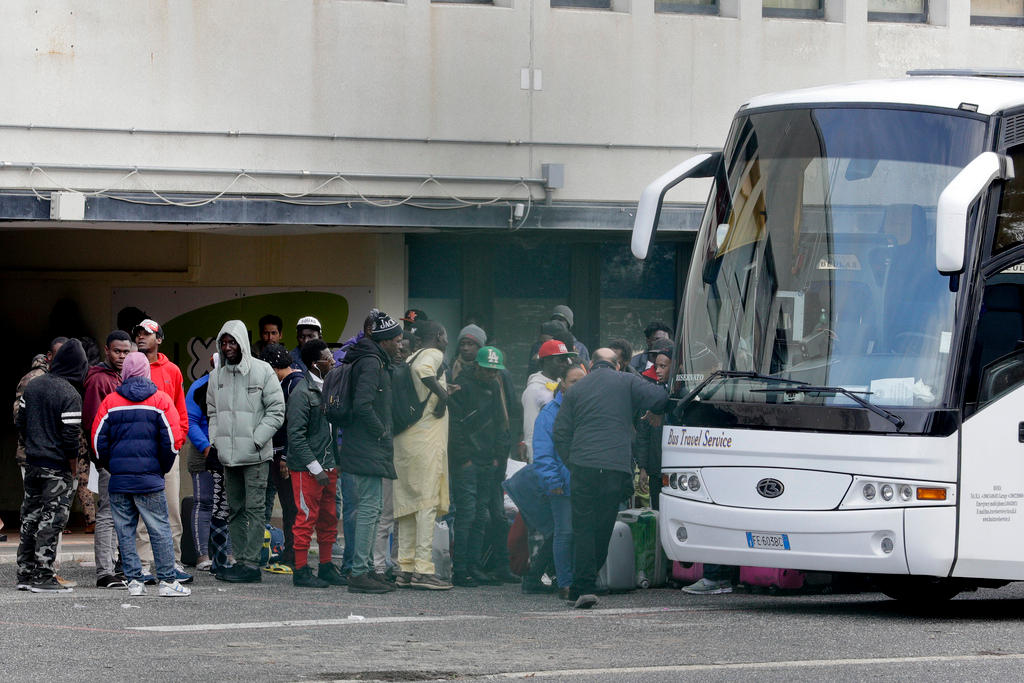 Un bus con decine di migranti pronti a salire per essere trasferiti dal centro di Castelnuovo.