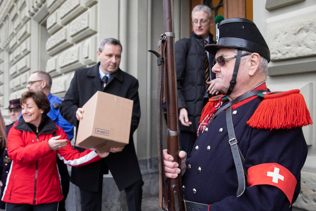 Campaigners with boxes and man with rifle and old Swiss army uniform
