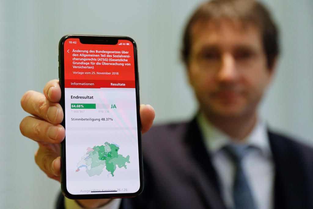 Un uomo mostra uno smartphone sul quale è stata scaricata l app VoteInfo.