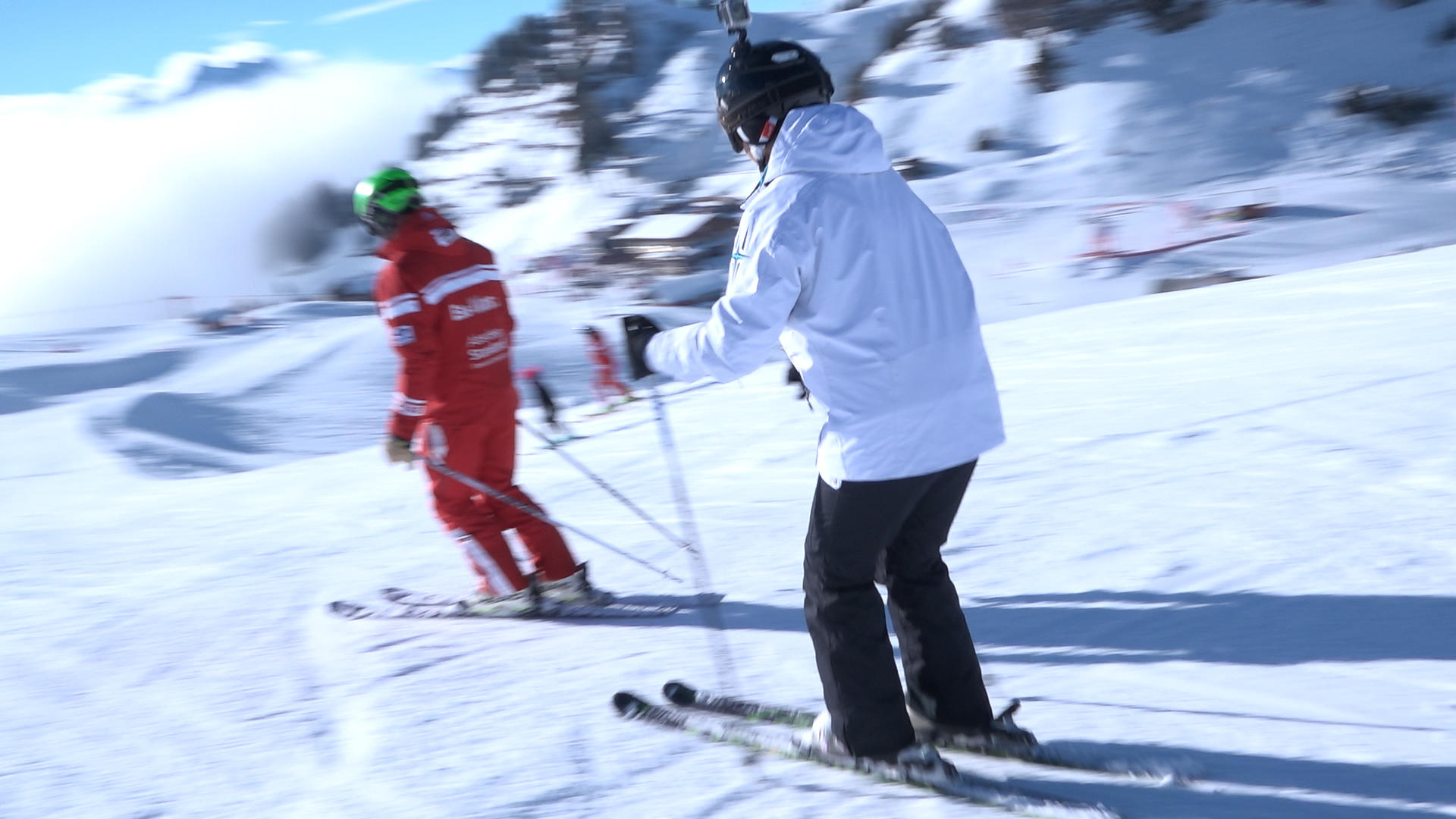 Woman skiing behind indtructor