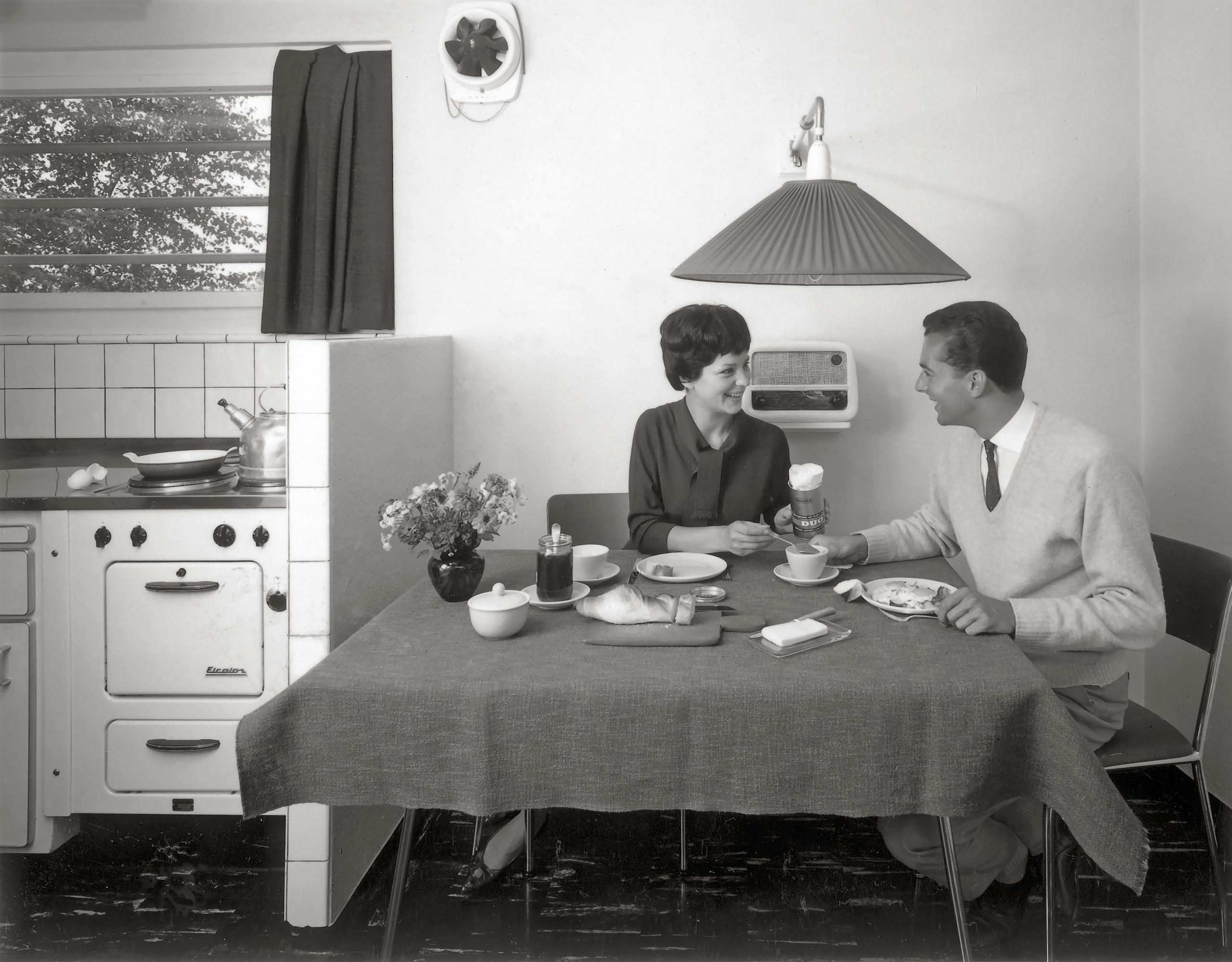 امرأة ورجل يجلسان إلى مائدة في المطبخ