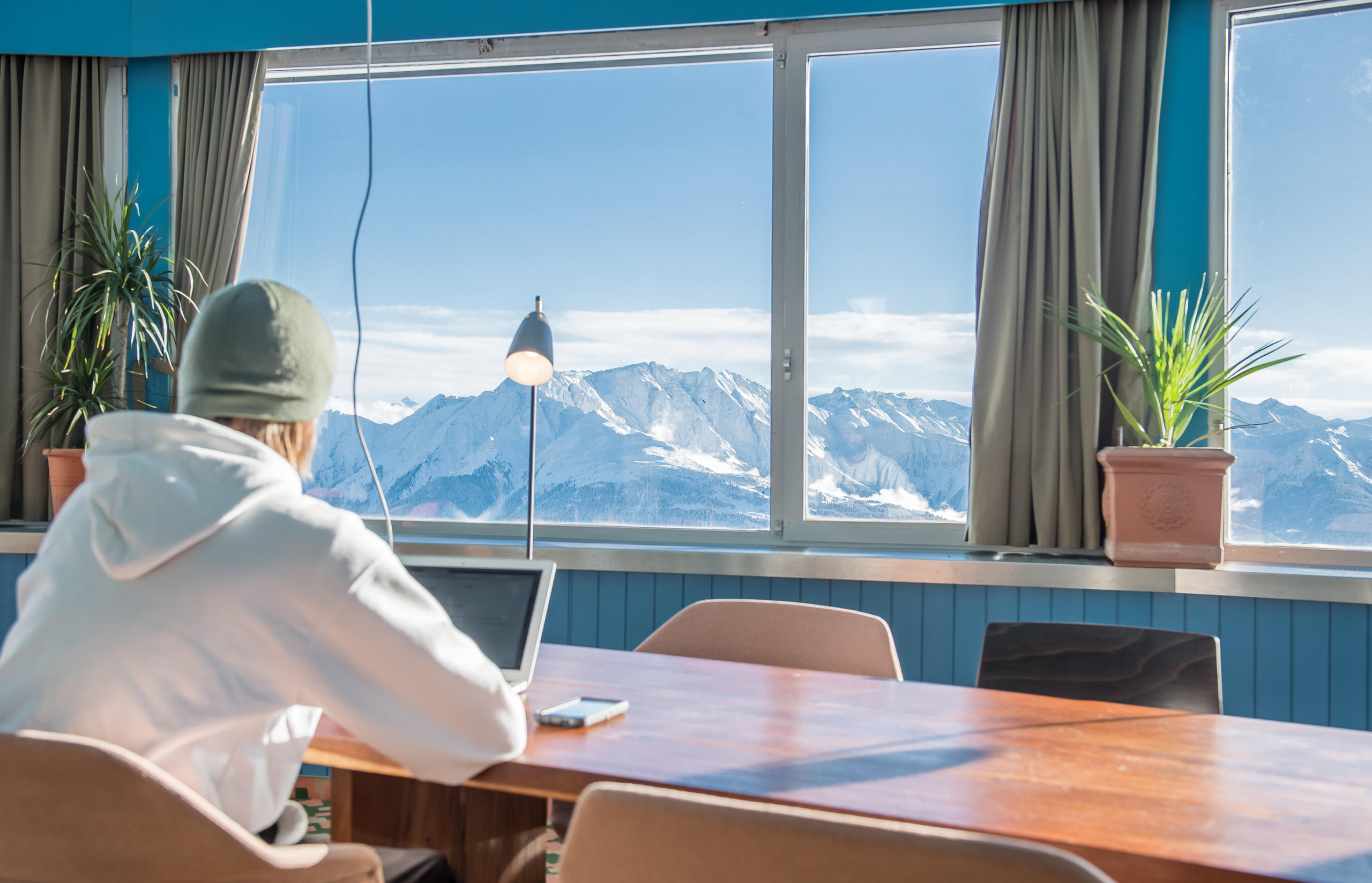 Man sitting t desk in office on top of mountain in Laax