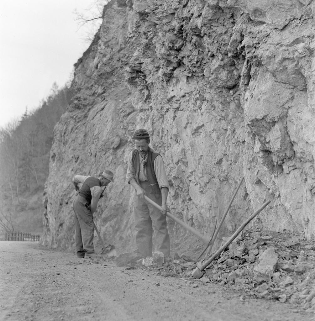 岩壁沿いに工事する二人の男性