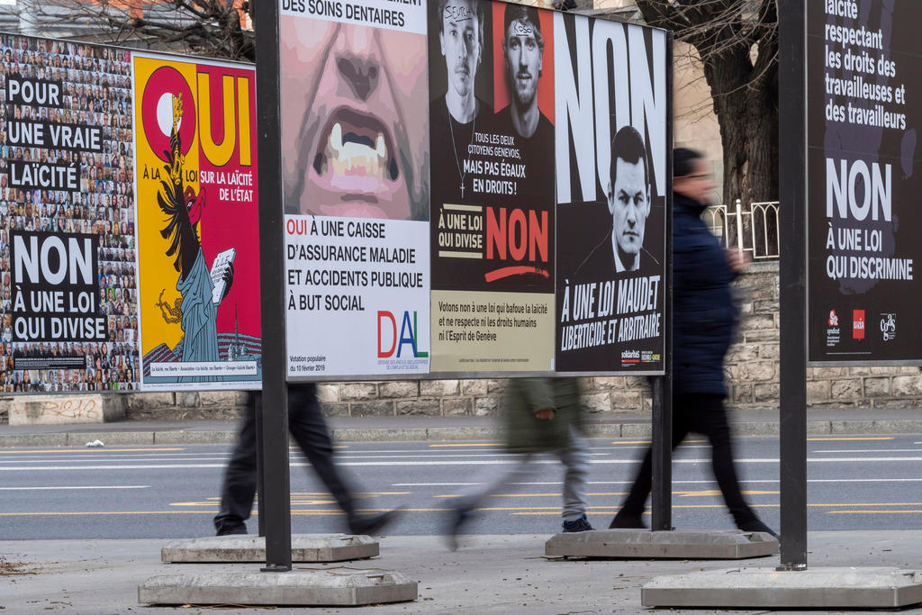 People pass in front of vote posters