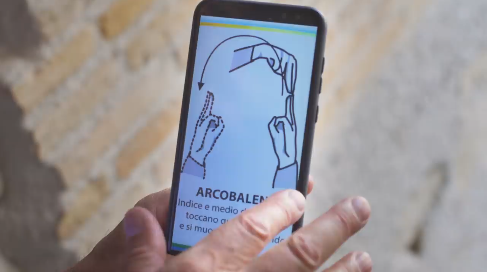Primo piano di un telefono cellulare con l illustrazione del segno Arcobaleno ; dito punta verso lo schermo