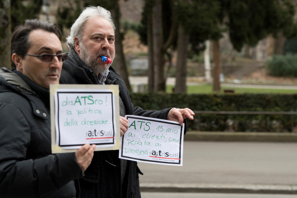 Deux hommes devant un parc à Berne avec des pancartes dans les mains