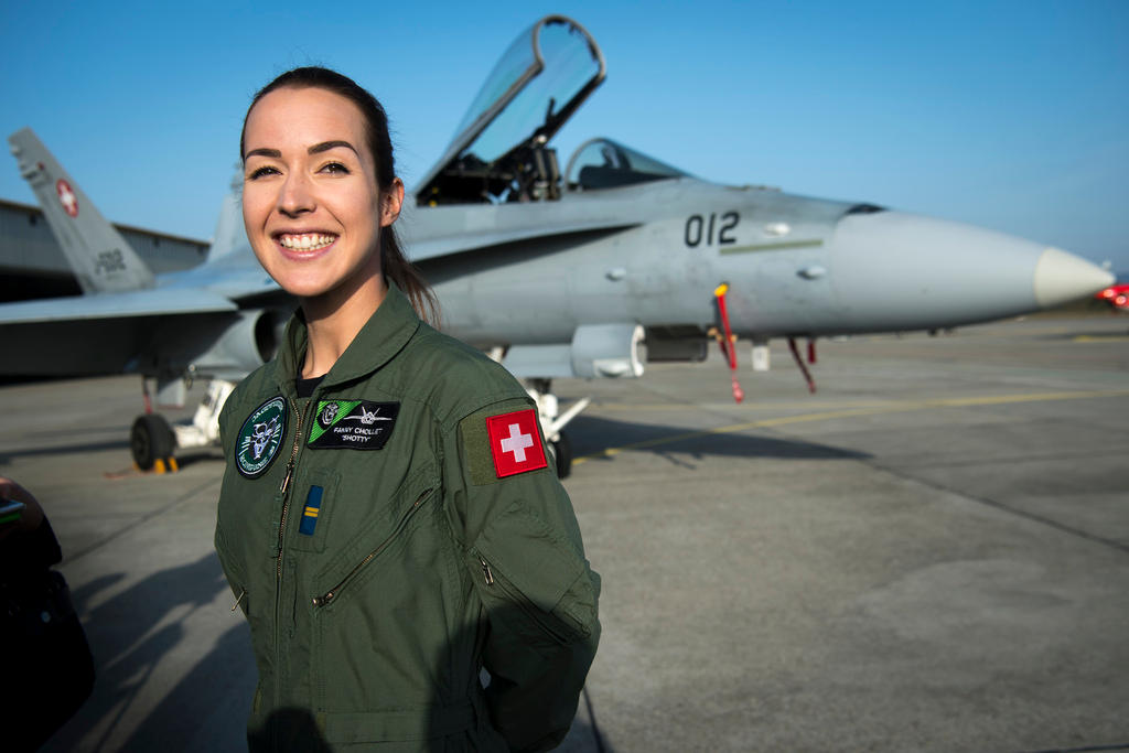 Fanny Chollet sorridente con la divisa dell aviazione svizzera a terra posa davanti a un FA/18