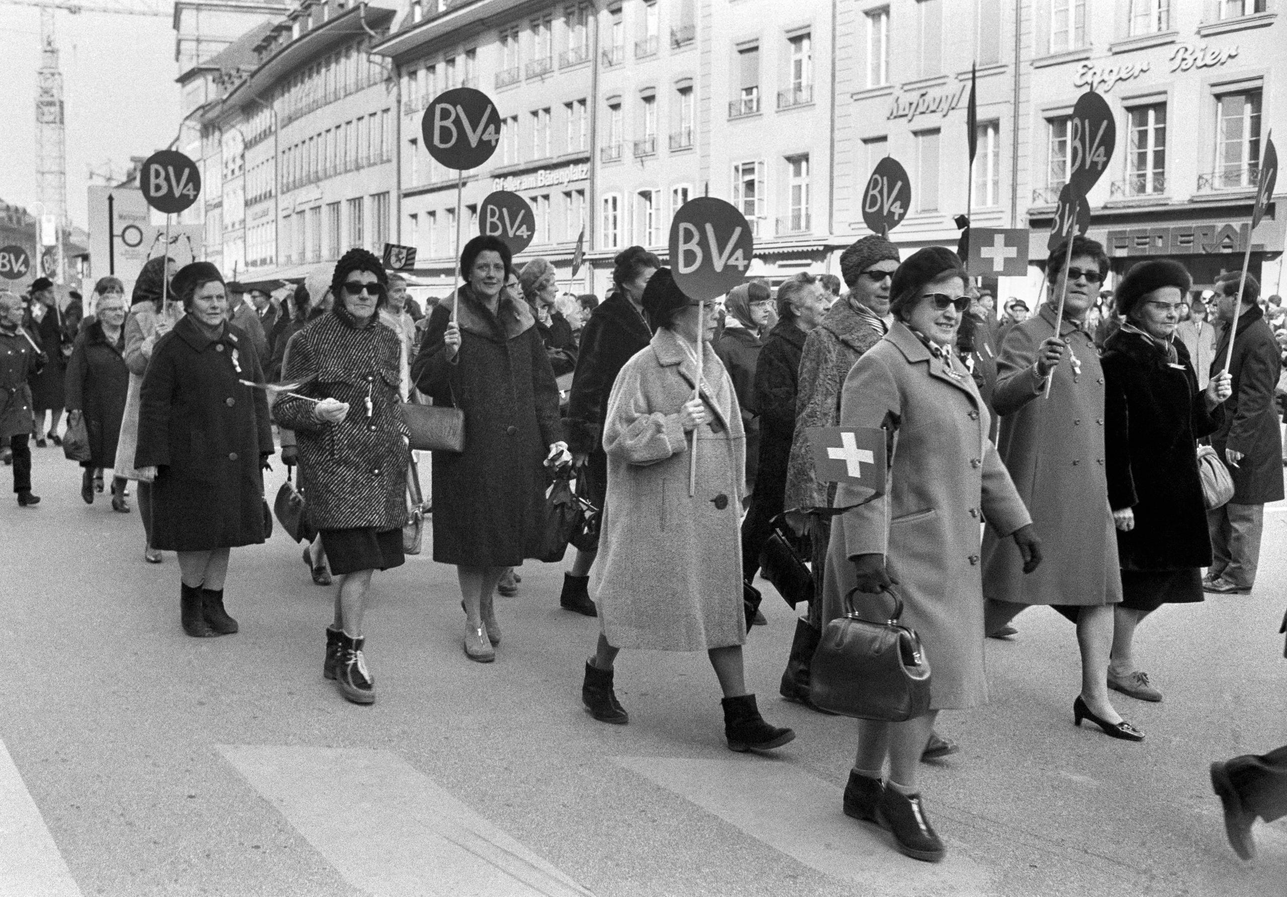 「BV4」と書かれたプラカードを掲げて行進する大勢の女性たち