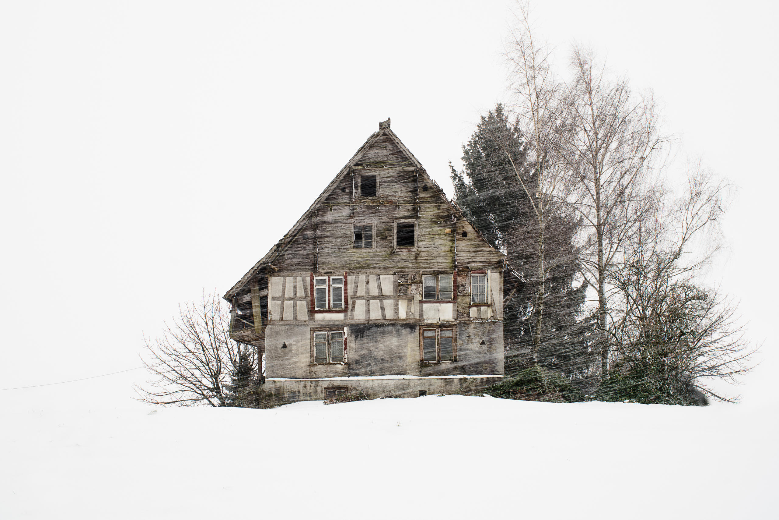 Chalet umgeben von Bäumen im Schneesturm