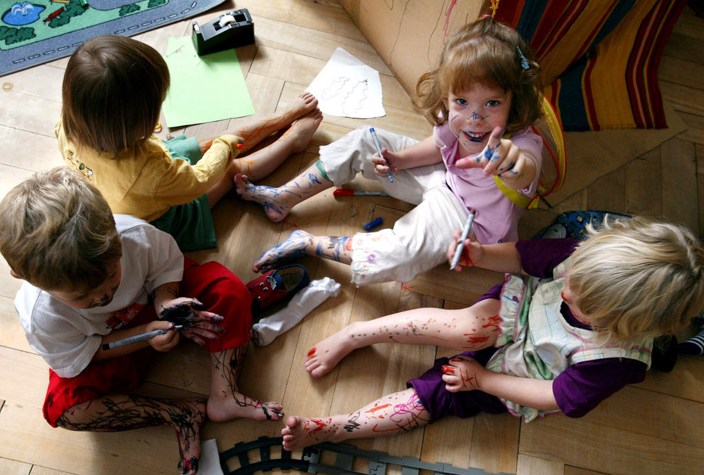 Four children with painted faces in a creche