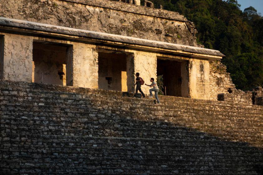 Dos hombres suben una pirámide maya