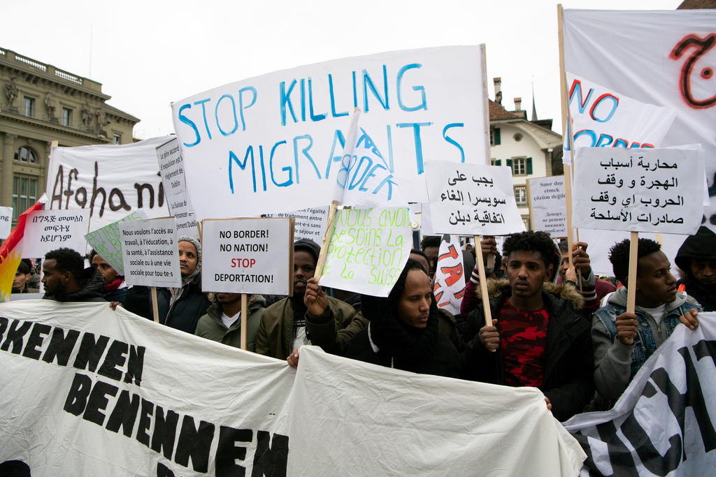 Demonstrators wave banners against immigration policy