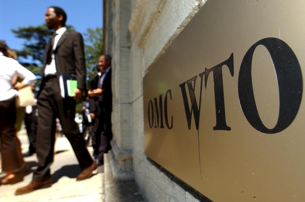 Ein goldenes Schild mit der Aufschrift WTO an einer Mauer.