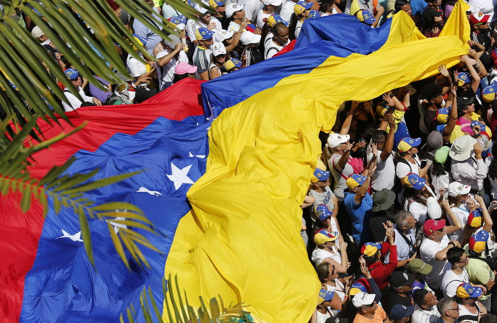 manifestantes con una bandera venezolana gigante