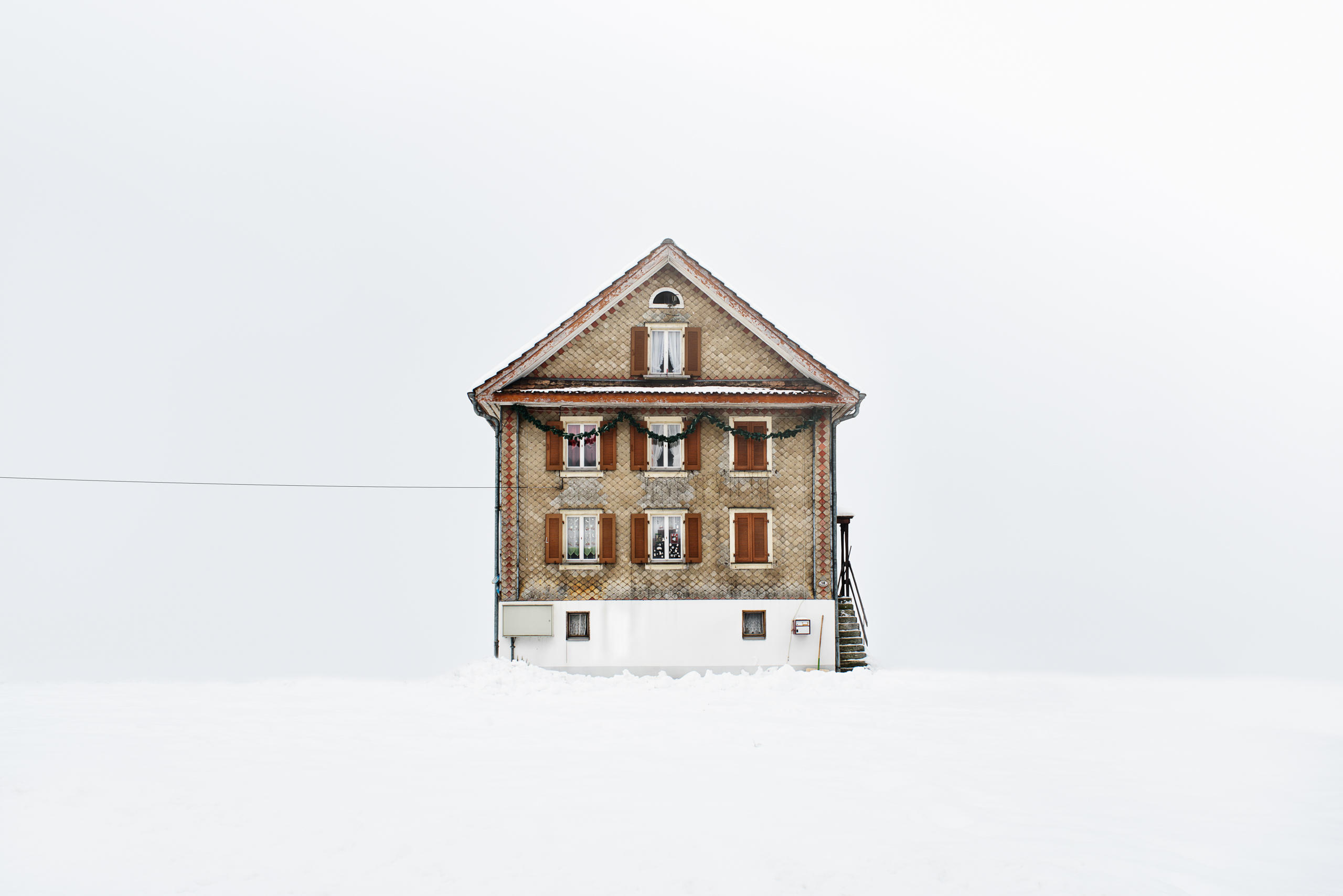 Chalet mit Holzschindeln und dunkelroten Fensterläden