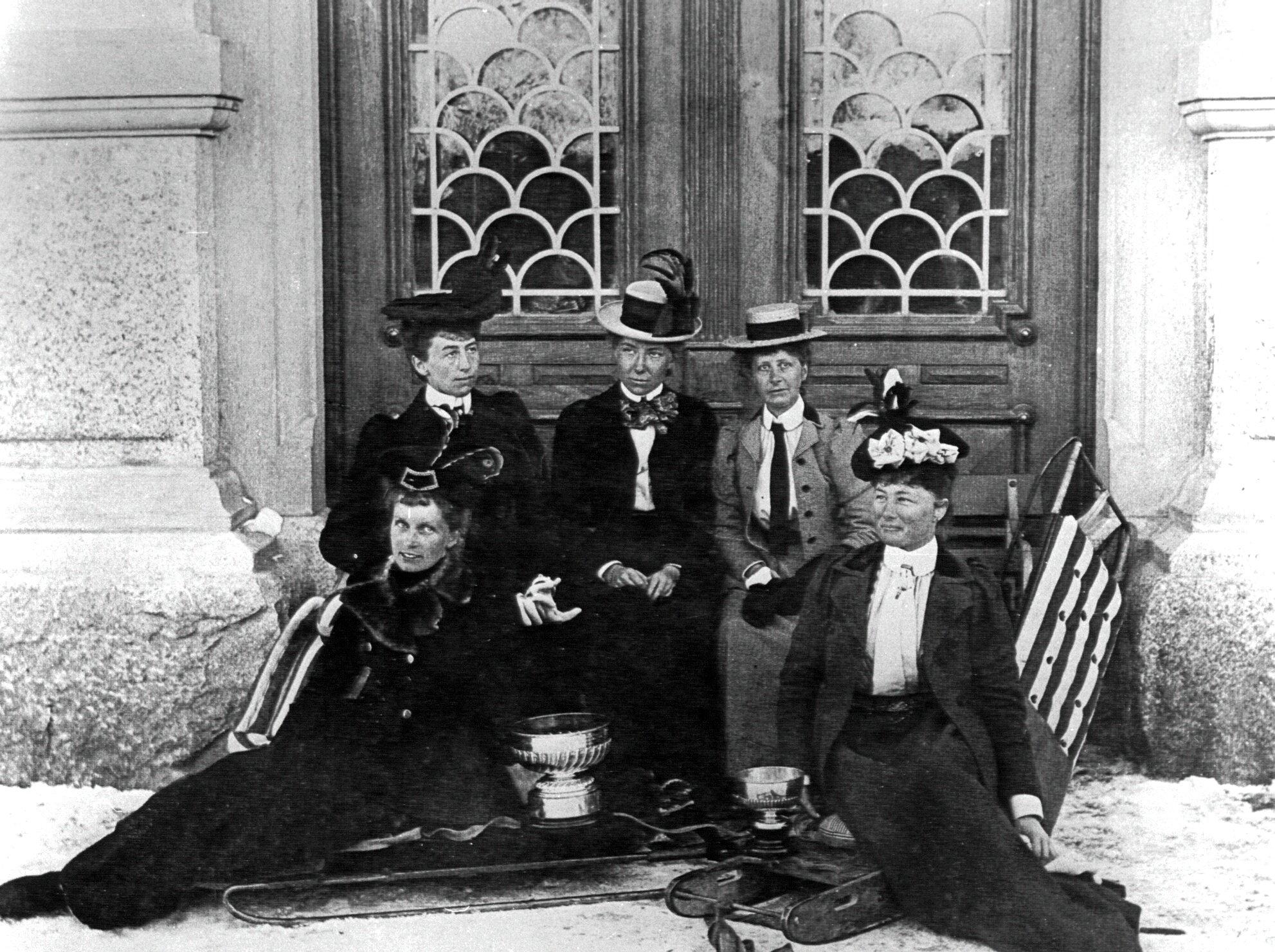 نساء يجلسن أمام بوابة منزل