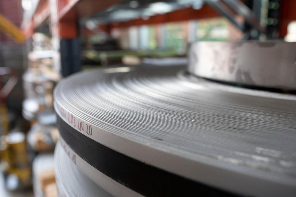 Primo piano di un grosso disco o forse bobina d acciaio all interno di uno stabilimento