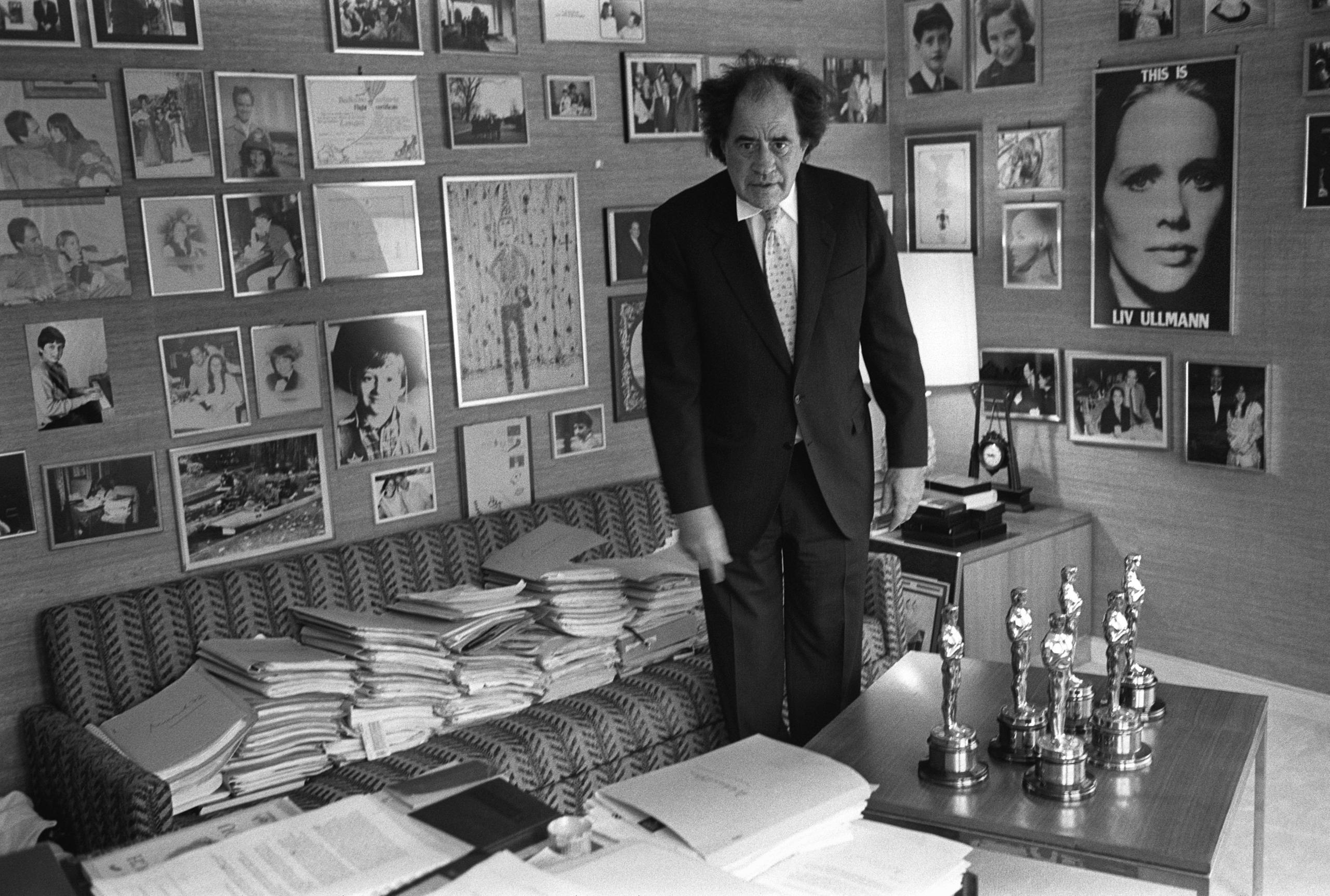 Arthur Cohn stands in a room full of scripts and pictures on the walls