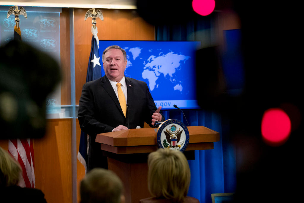 Il segretario di Stato Pompeo parla da un pulpito accanto a una bandiera USA e un monitor con la mappa del mondo