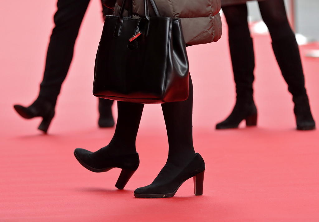 Piernas de mujeres caminando sobre una alfombra roja