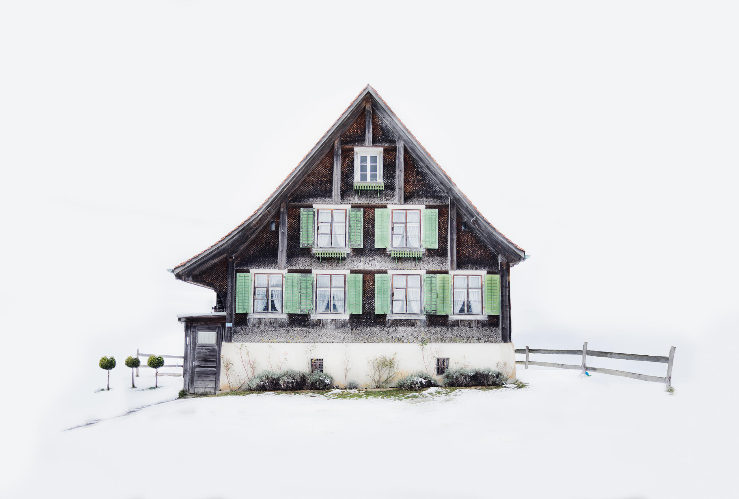 Chalet aus dunklem Holz mit hellgrünen Fensterläden