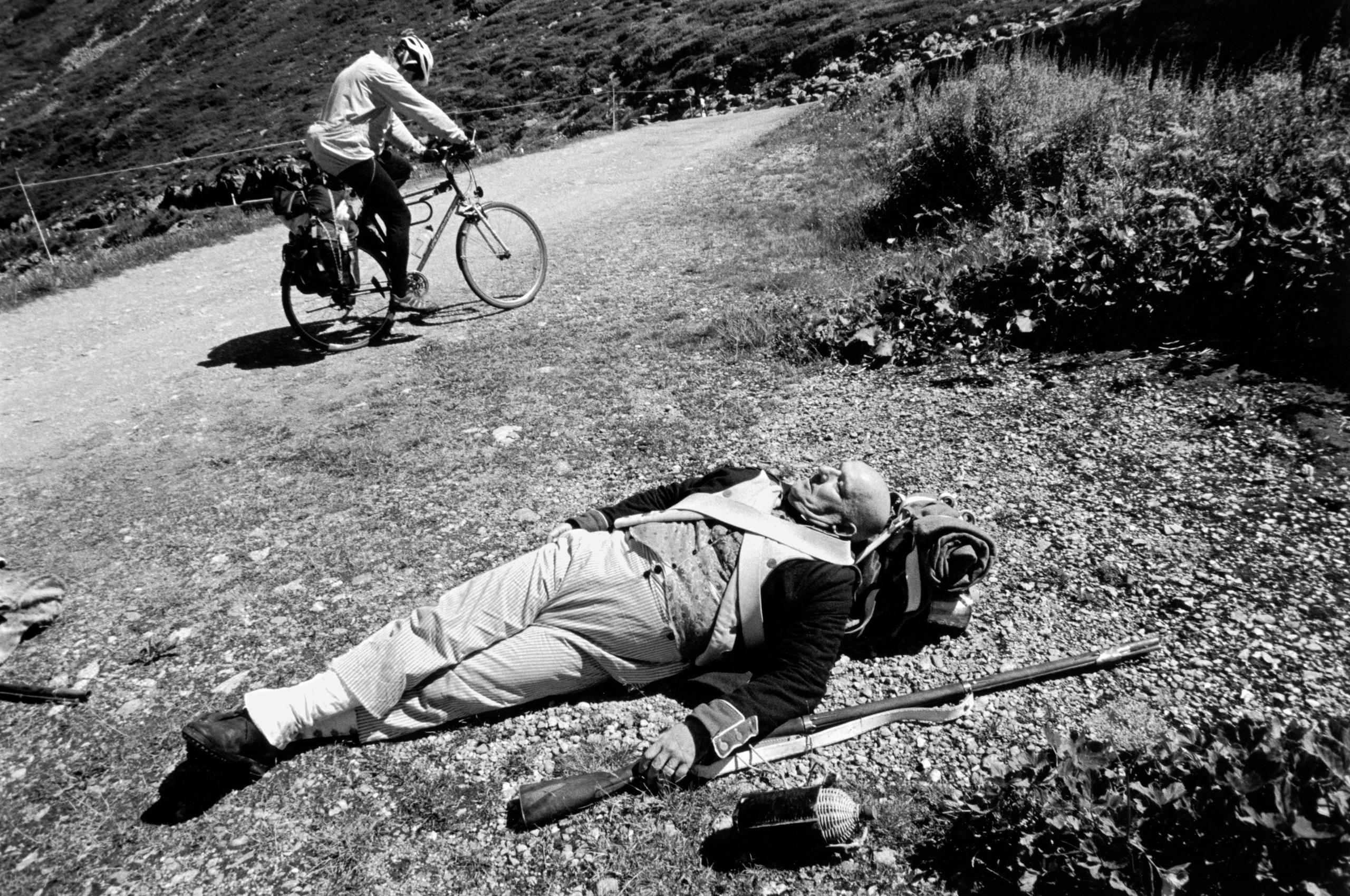 Un hombre con uniforme militar antiguo acostado sobre el césped.