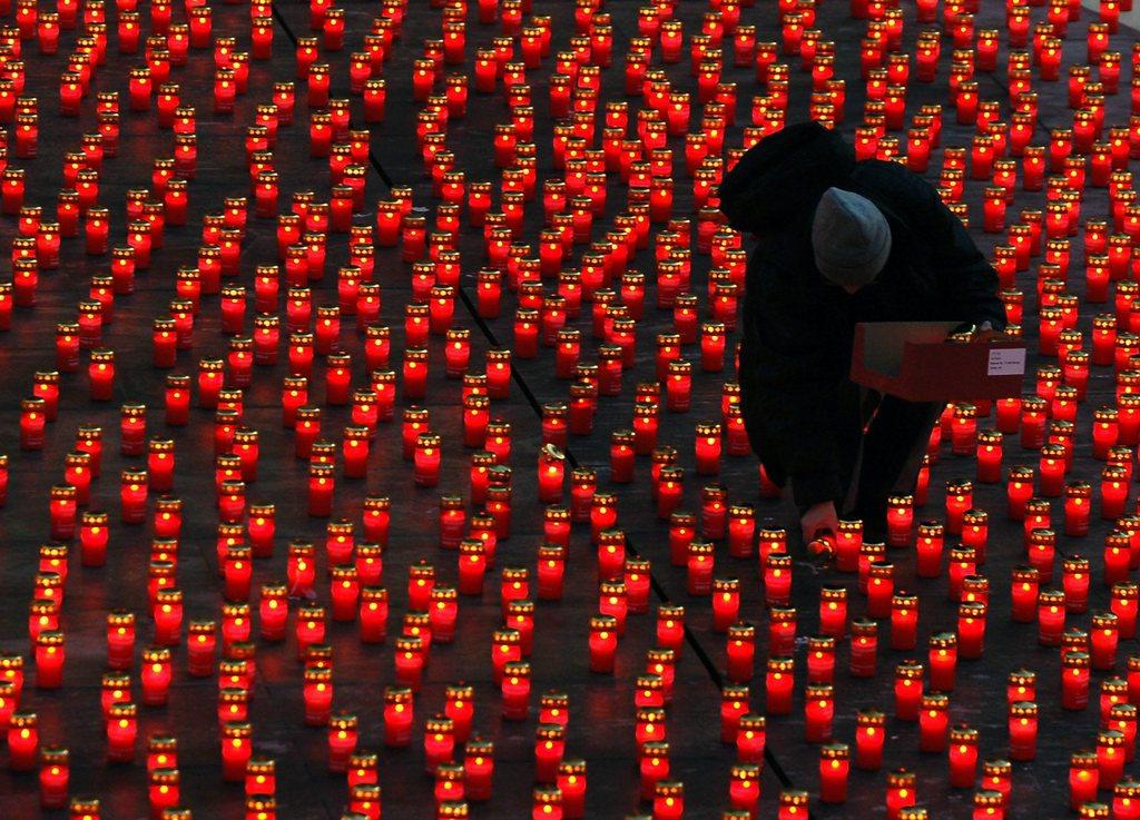 Sea of red candles with person wearing black