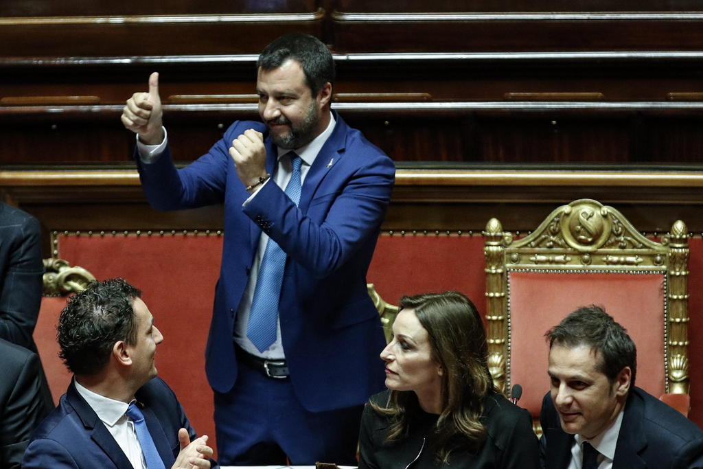 Matteo Salvini in piedi fa un gesto di approvazione e sorride nell aula del Senato italiano