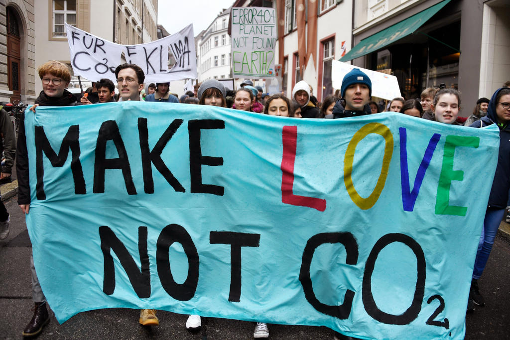Giovani che manifestano per il clima con un cartellone esplicito: Fate l amore non il co2