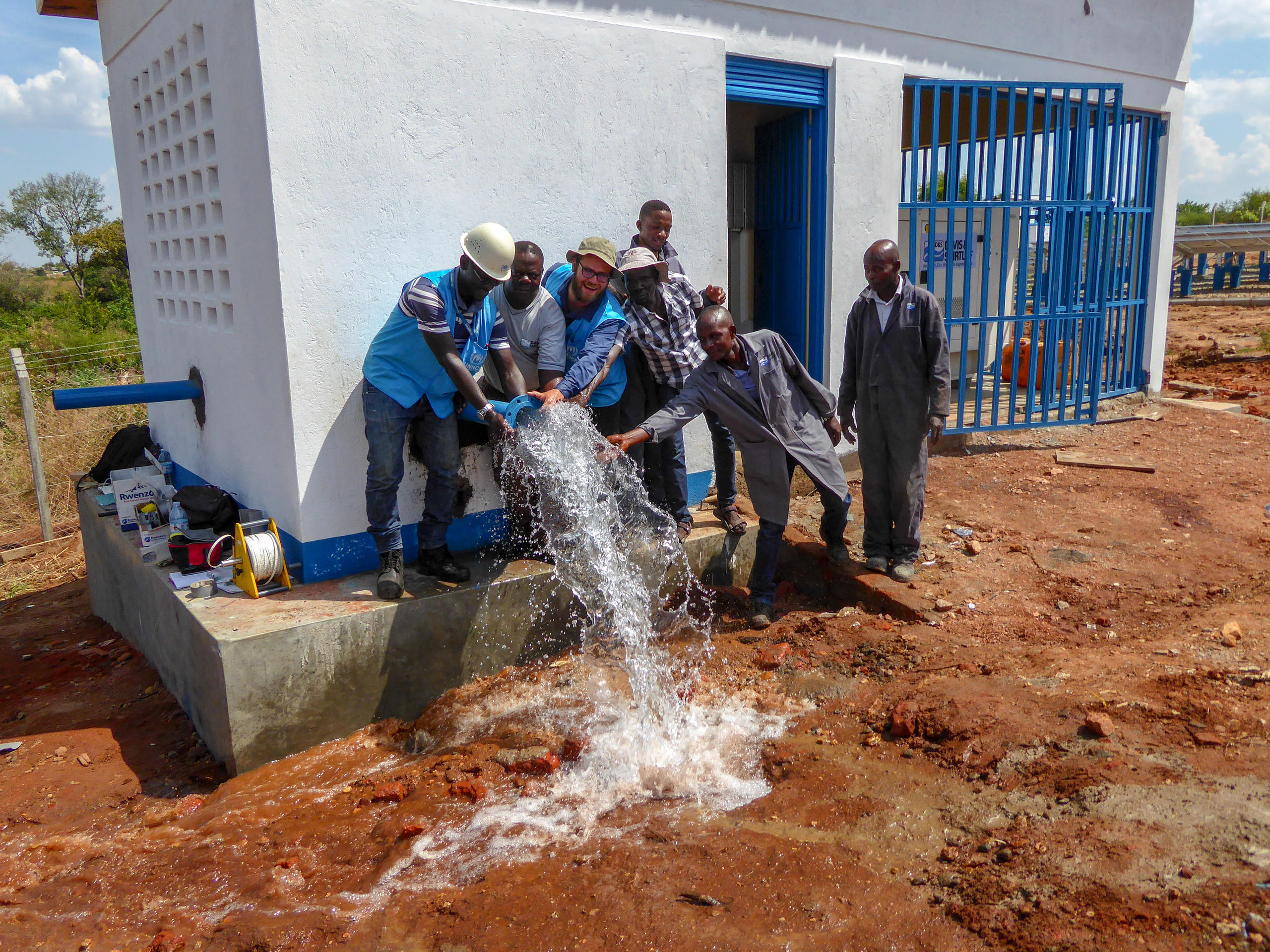 Grupo de personas alrededor de fuente de agua.