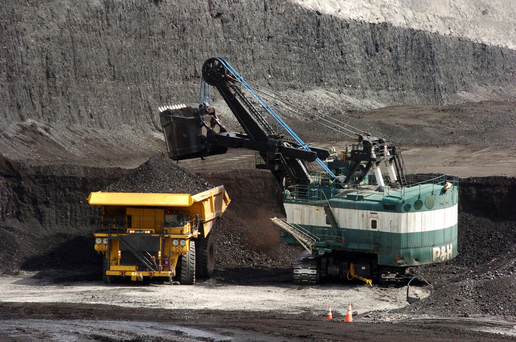 Crane lowers coal onto a truck in a coal mine