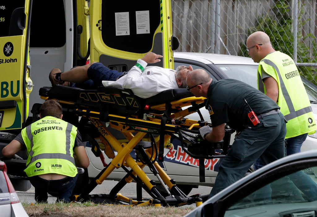 Ambulance staff take a man from outside a mosque in central Christchurch