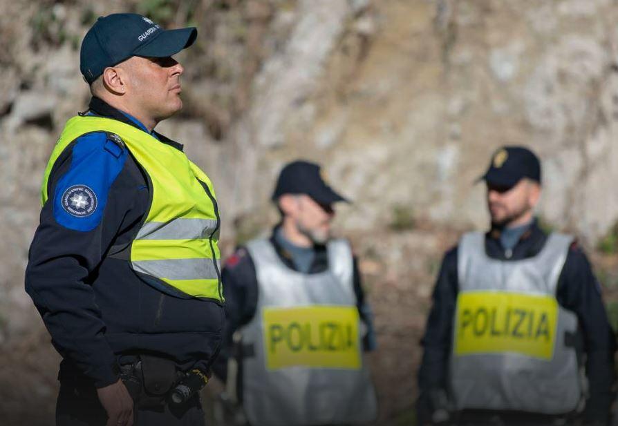 In primo piano una guardia di confine svizzera. Sullo sfondo due agenti della polizia di Stato italiana.