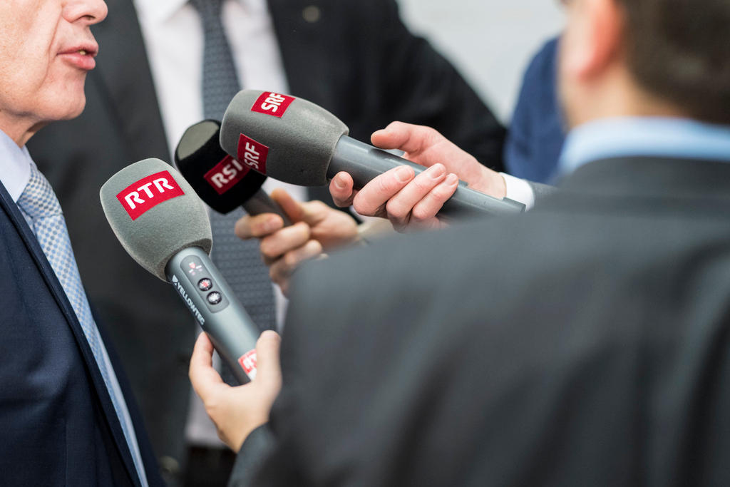 In primo piano i microfoni dei diversi media svizzeri mentre intervistano Ueli Maurer