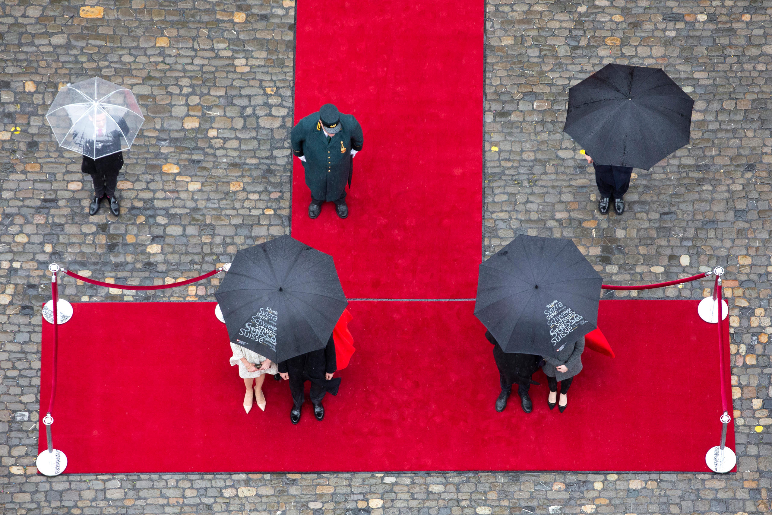 people at a ceremony with umbrellas