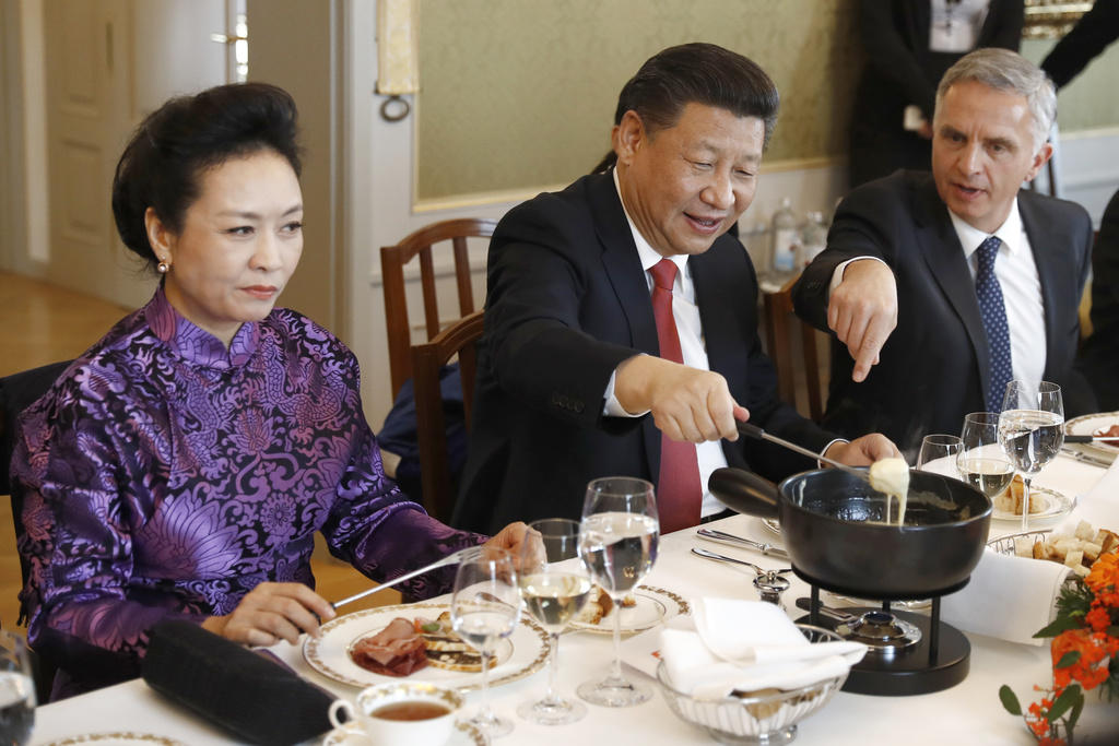 2017年，中國國家主席習近平正在嘗試奶酪火鍋，他的妻子試吃後表情一言難盡