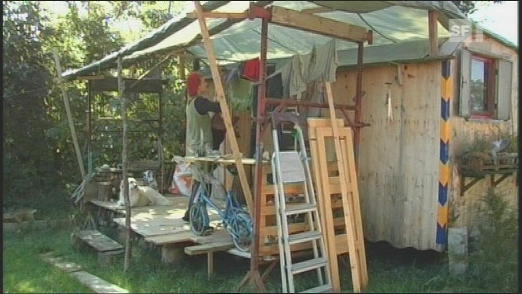 A resident of a caravan hangs up laundry