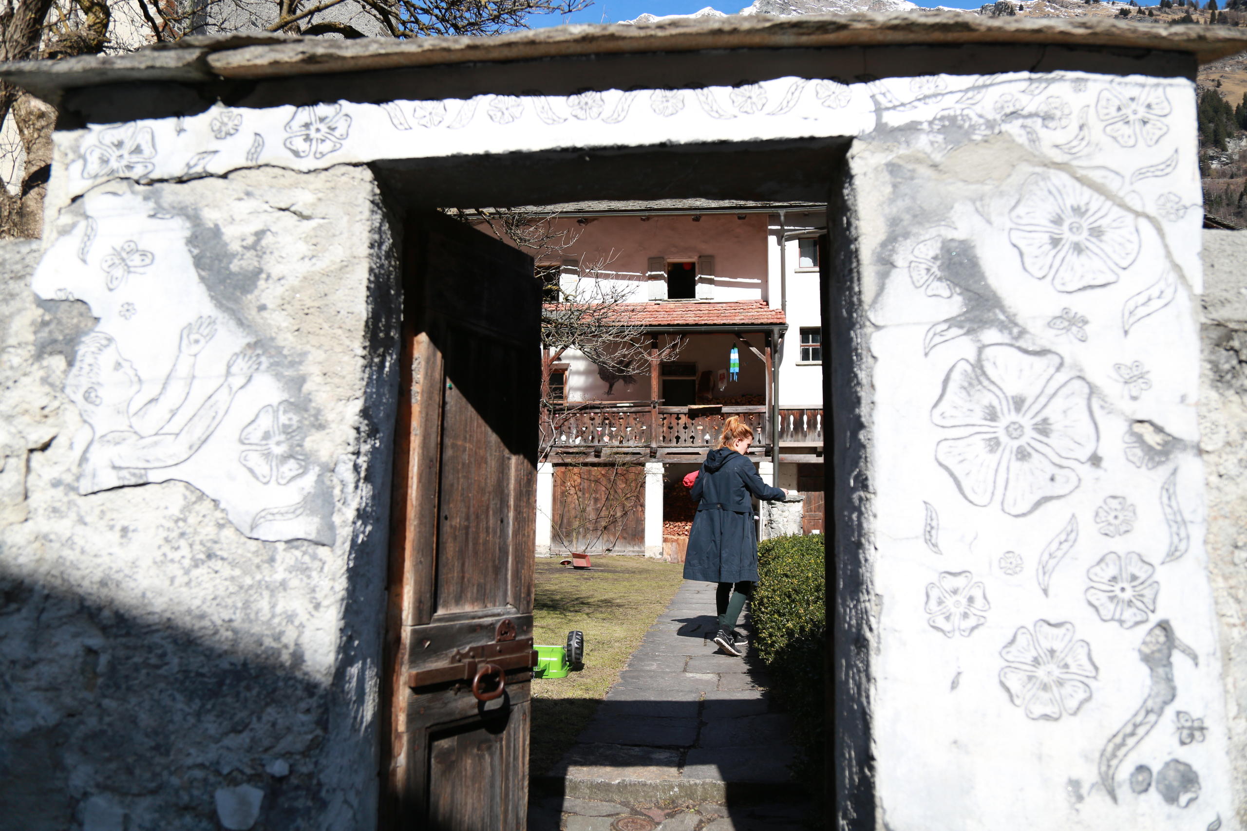 Femme vue de dos à travers une porte d entrée.