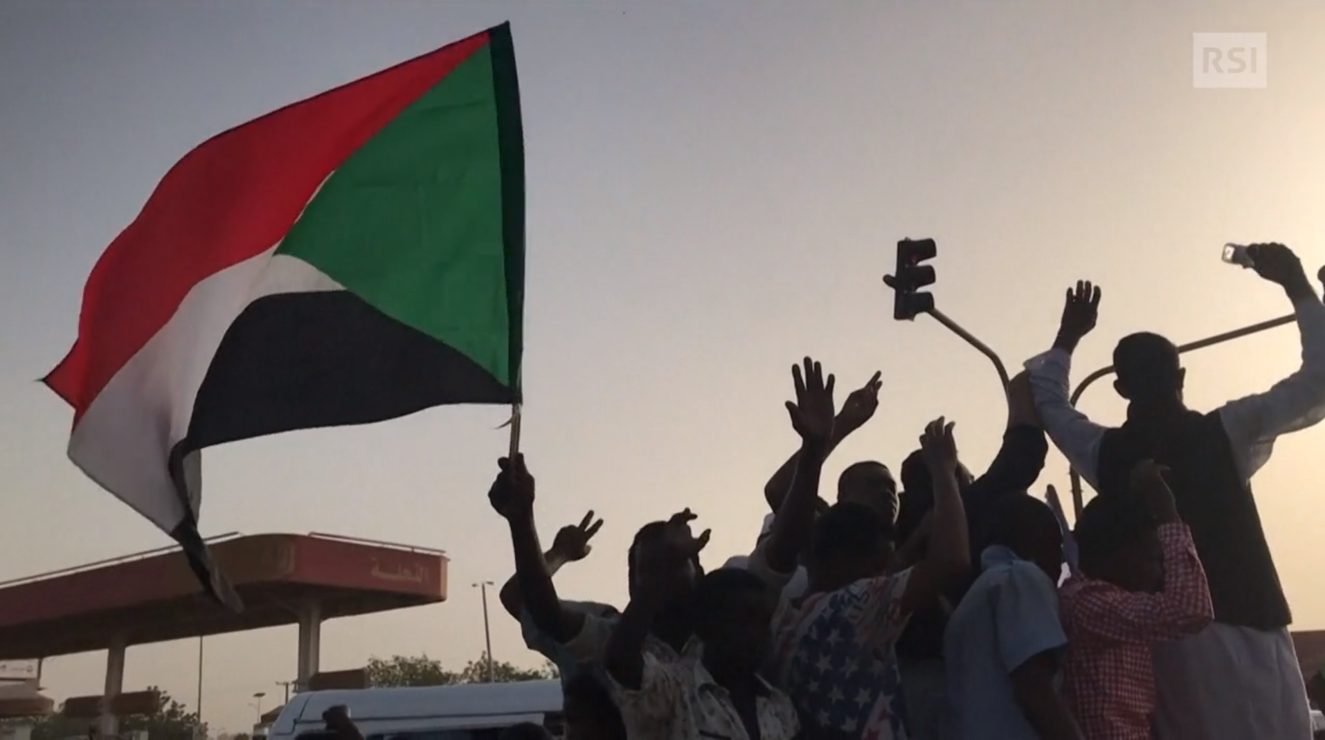Immagini di dimostranti per strada all alba; sventolano bandiere sudanesi e fanno gesti di vittoria