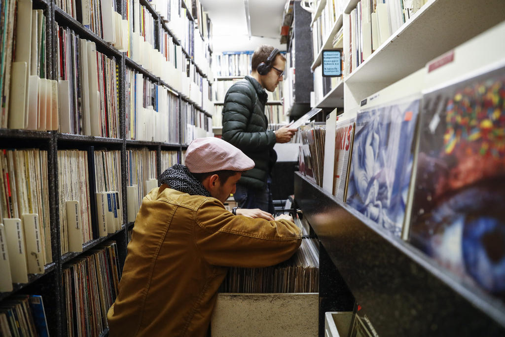 Deux hommes à la recherche de disques vinyl dans un magasin spécialisé