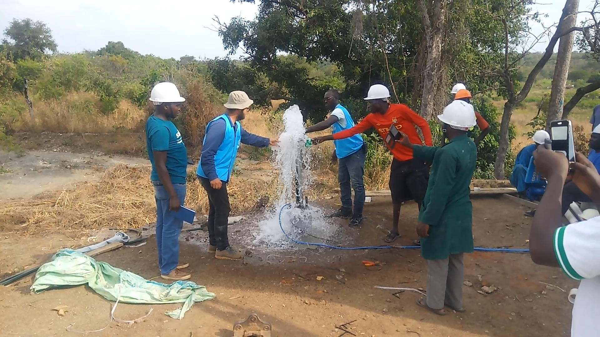 technicians around water hole in Bidi Bidi