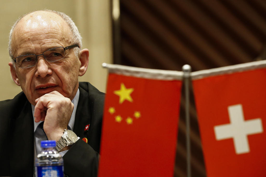 Finanzminister Ueli Maurer, davor zwei Tischfahnen von China und der Schweiz